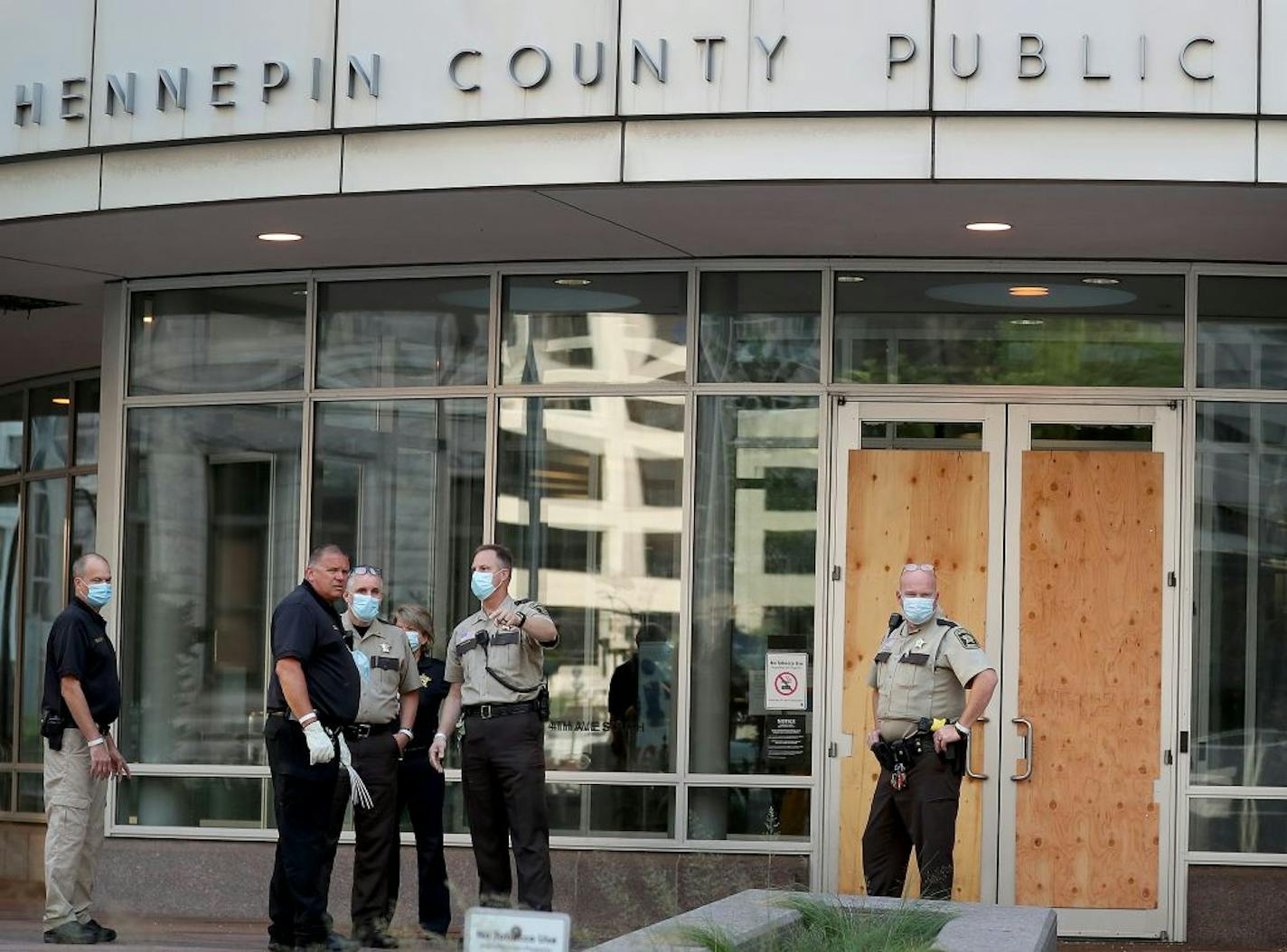 Law enforcement officers outside the Hennepin County Public Safety Facility Tuesday morning, where a demonstration in response to the police shooting of a black man in Kenosha, Wisc., turned violent late Monday, where protesters broke front entry door windows to the jail.