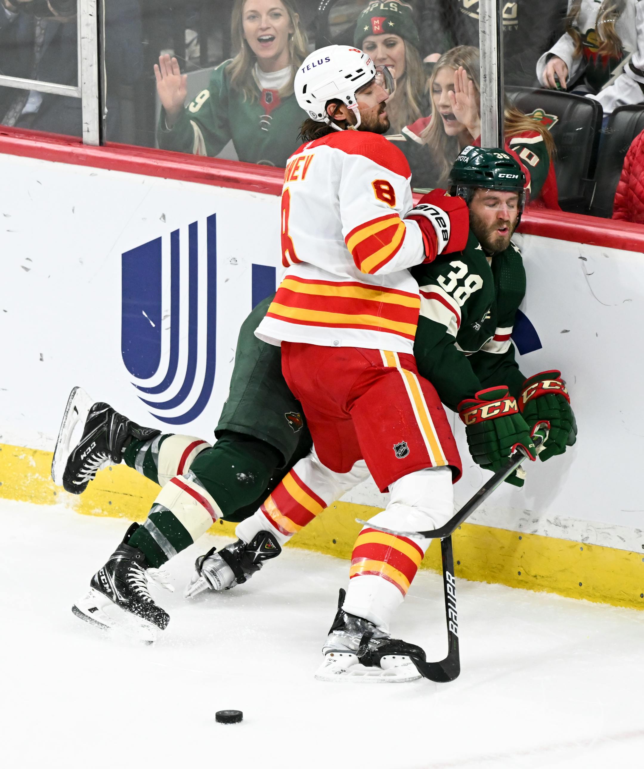 Minnesota Wild right wing Ryan Hartman (38) is checked into the boards by Calgary Flames defenseman Chris Tanev (8) during the third period.
