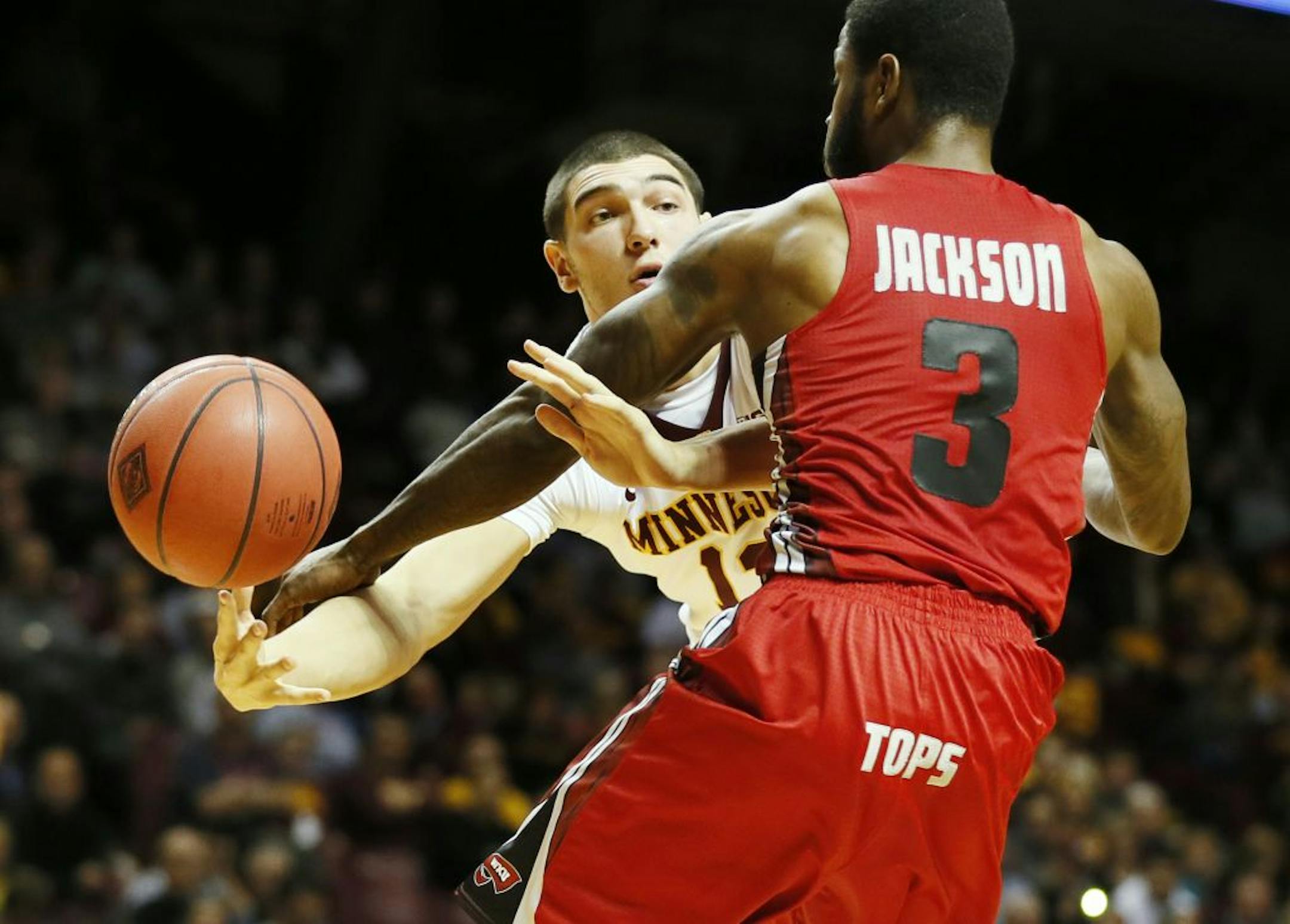 Minnesota Golden Gophers forward Josh Martin (13)passed the ball around Western Kentucky Hilltoppers guard Trency Jackson (3) Tuesday at Williams Arena November 18, 2014 in Minneapolis, Minnesota.