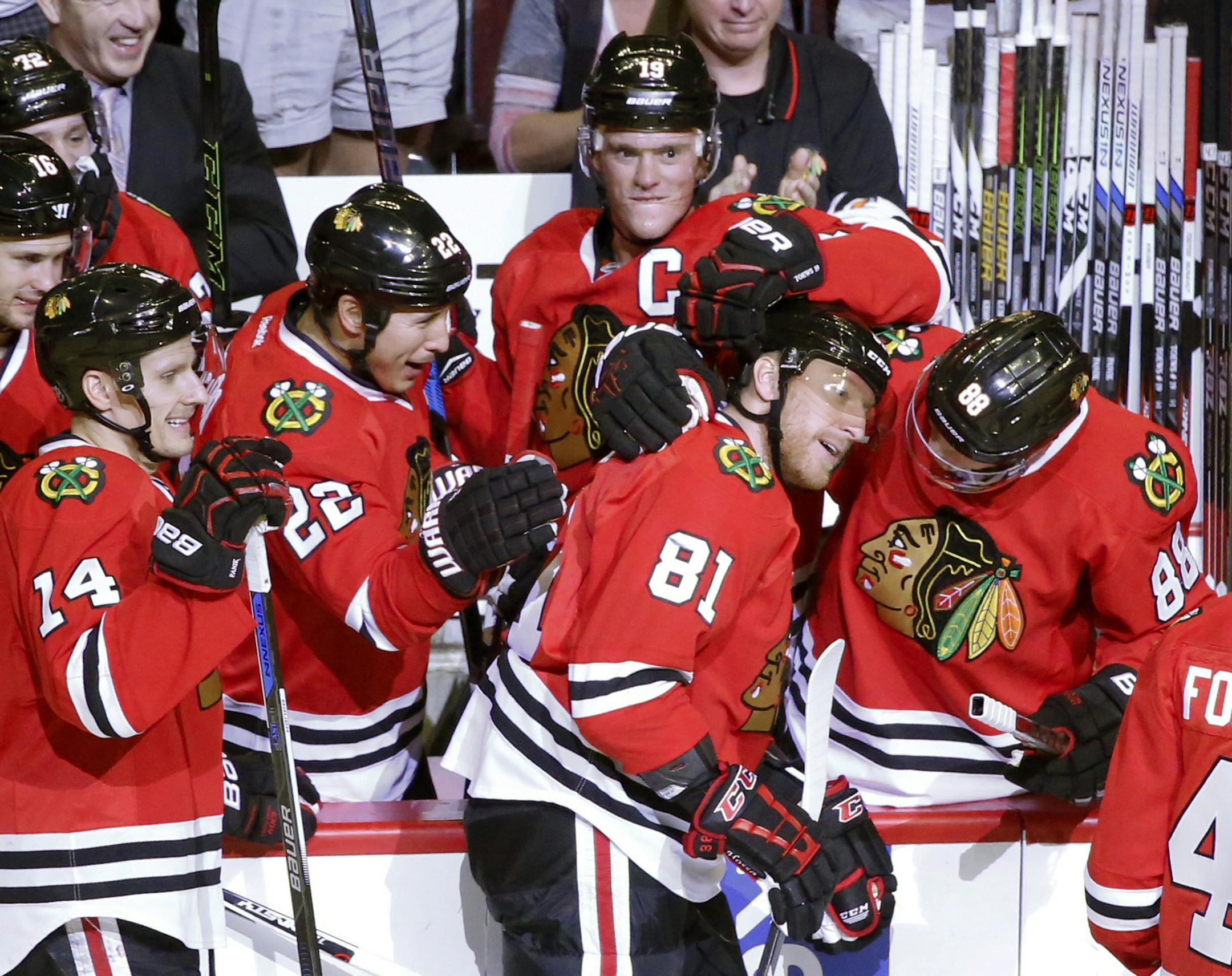 The Chicago Blackhawks mob Marian Hossa (81) after Hossa scored his 500th career goal, during the second period of an NHL hockey game against Philadelphia Flyers on Tuesday, Oct. 18, 2016, in Chicago. (AP Photo/Charles Rex Arbogast)