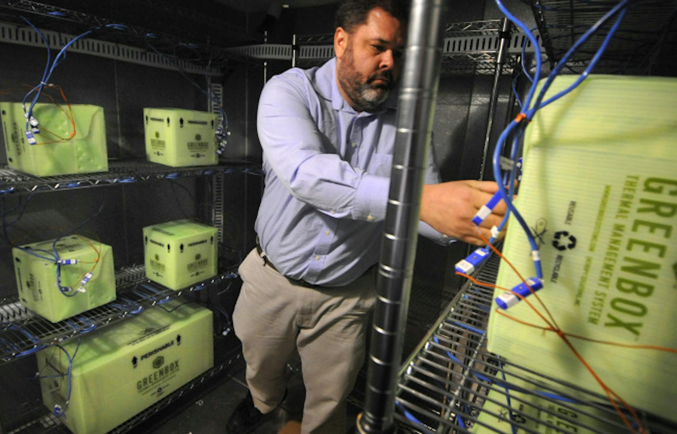 Preston Williams, chief technology officer for Entropy Solutions Inc., checked temperatures inside samples of its reusable Green Box, a packaging system developed by the Eden Prairie-based company that preserves preprogrammed temperatures during shipment of perishable products