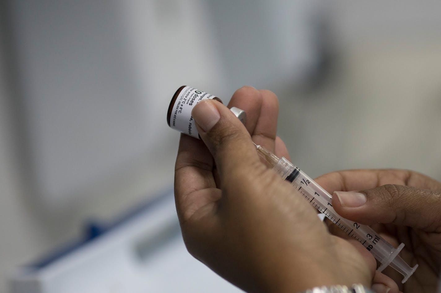 A health worker prepares a syringe with a vaccine against measles.