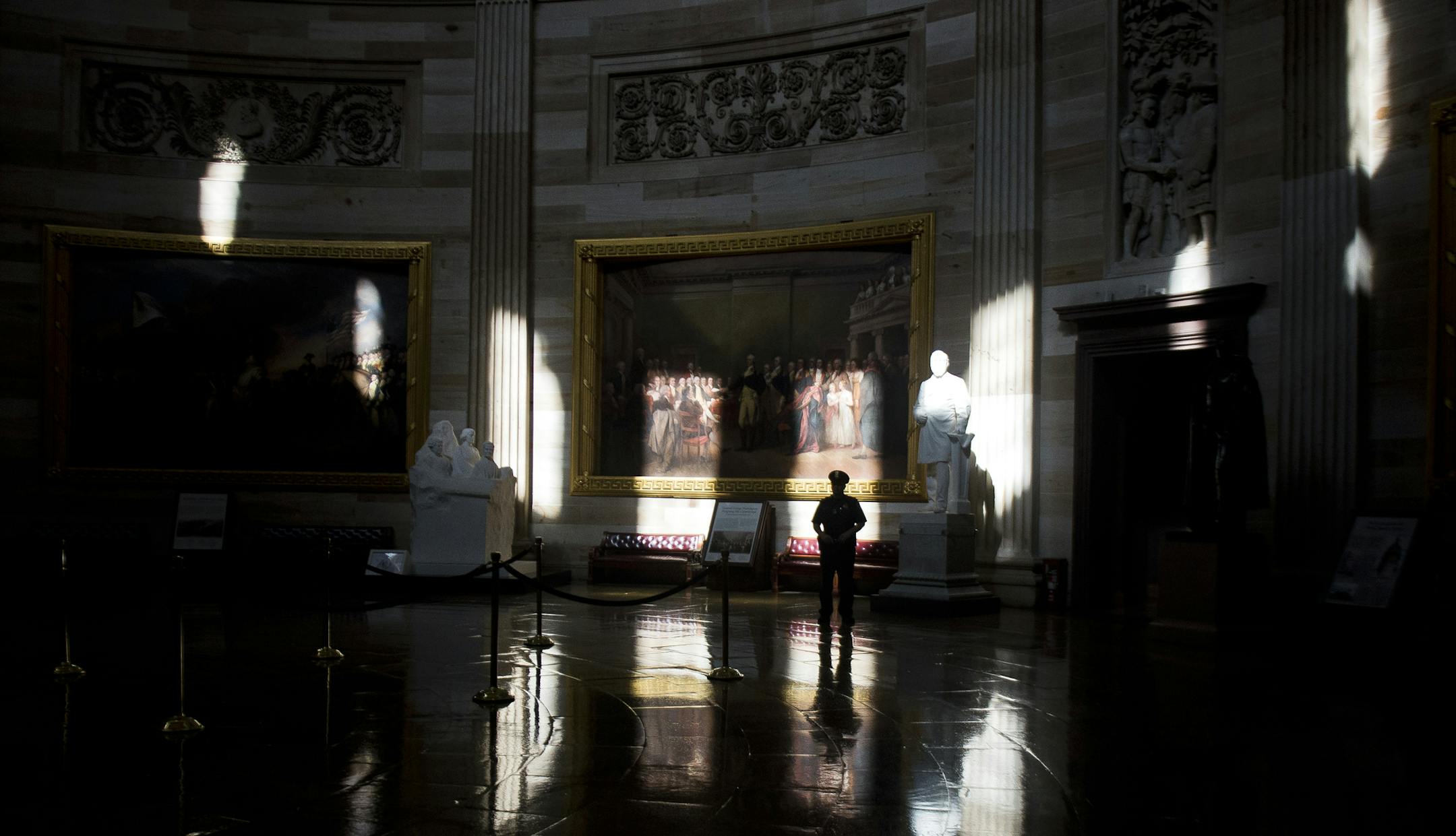 A guard stands watch in the empty rotunda of the Capitol during Columbus Day in Washington, Oct. 14, 2013. Democrats said Sunday that Sens. Harry Reid (D-Nev.) the majority leader, and Mitch McConnell (R-Ky.) the Republican leader, who spoke only briefly by telephone, were inching forward, and that a breakthrough was possible before the debt default deadline on Thursday. (Gabriella Demczuk/The New York Times)