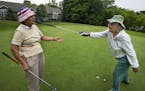 At the Thompson Oaks Golf Course in West St. Paul, Harriet Anderson,75 who loves the people there gets "blessed" by playing partner Pat Tiller,90, aft