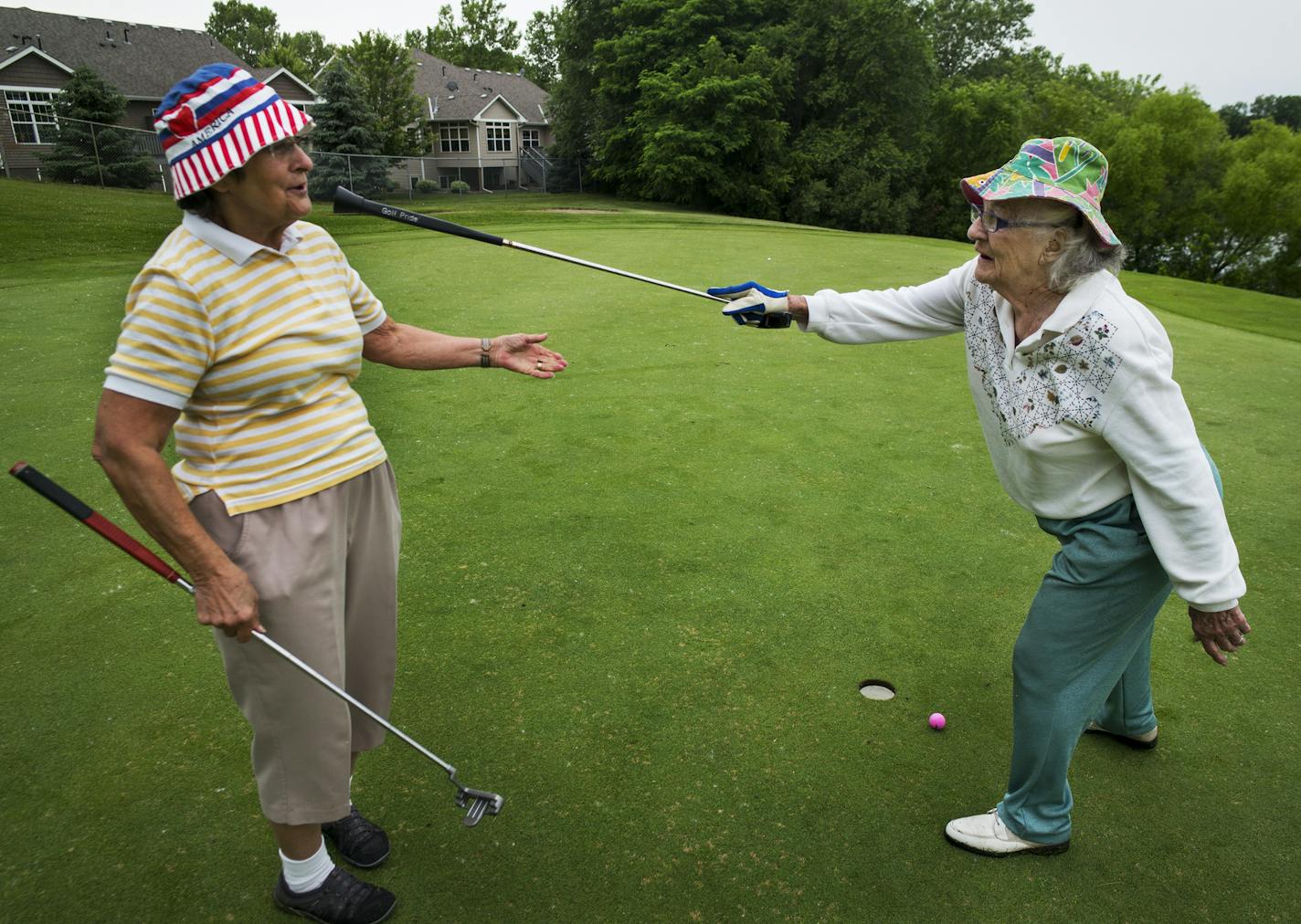 At the Thompson Oaks Golf Course in West St. Paul, Harriet Anderson,75 who loves the people there gets "blessed" by playing partner Pat Tiller,90, after Anderson sunk a putt that went in on a rope.This site might be one of the few municipal golf courses that would be repurposed as a possible town center.] Richard Tsong-Taatarii/rtsong-taatarii@startribune.com