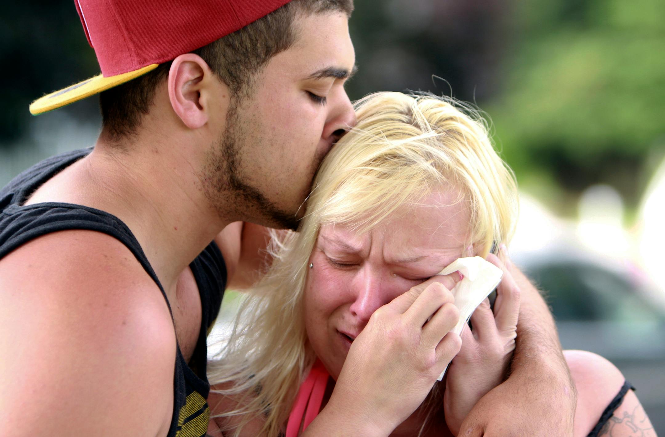 Two people comfort each other as they await word about the safety of students after a shooting at Reynolds High School, Tuesday, June 10, 2014, in Troutdale, Ore. A gunman killed a student at the high school east of Portland Tuesday and the shooter is also dead, police said.