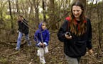 From right, Julie Lindquist, her eight-year-old daughter, Mikayla, and husband, Mike, search for a geocache in the woods at Longridge Park in Apple Va
