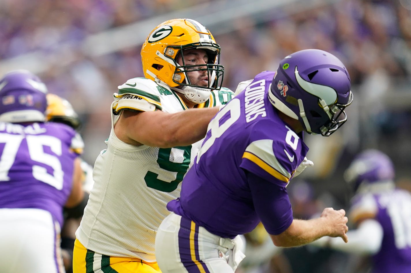 Minnesota Vikings quarterback Kirk Cousins (8) is hit after a pass by Green Bay Packers defensive end Dean Lowry (94) during the first half of an NFL football game Sunday, Sept. 11, 2022, in Minneapolis. (AP Photo/Abbie Parr)