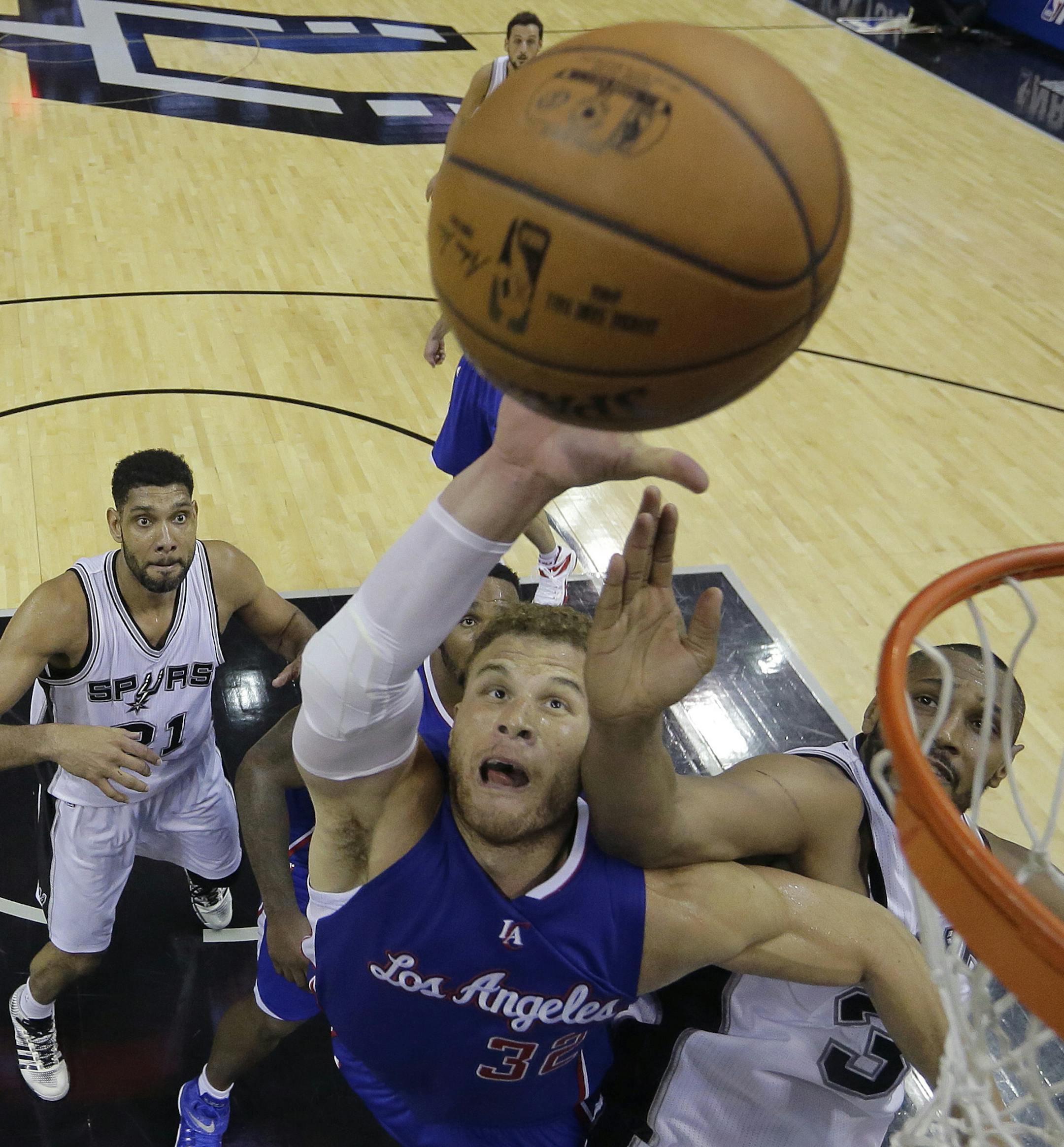 Los Angeles Clippers' Blake Griffin, center, and San Antonio Spurs' Boris Diaw, right, battle for a rebound during the second half of Game 4 in an NBA basketball first-round playoff series, Sunday, April 26, 2015, in San Antonio. Los Angeles won 114-105. (AP Photo/Darren Abate)