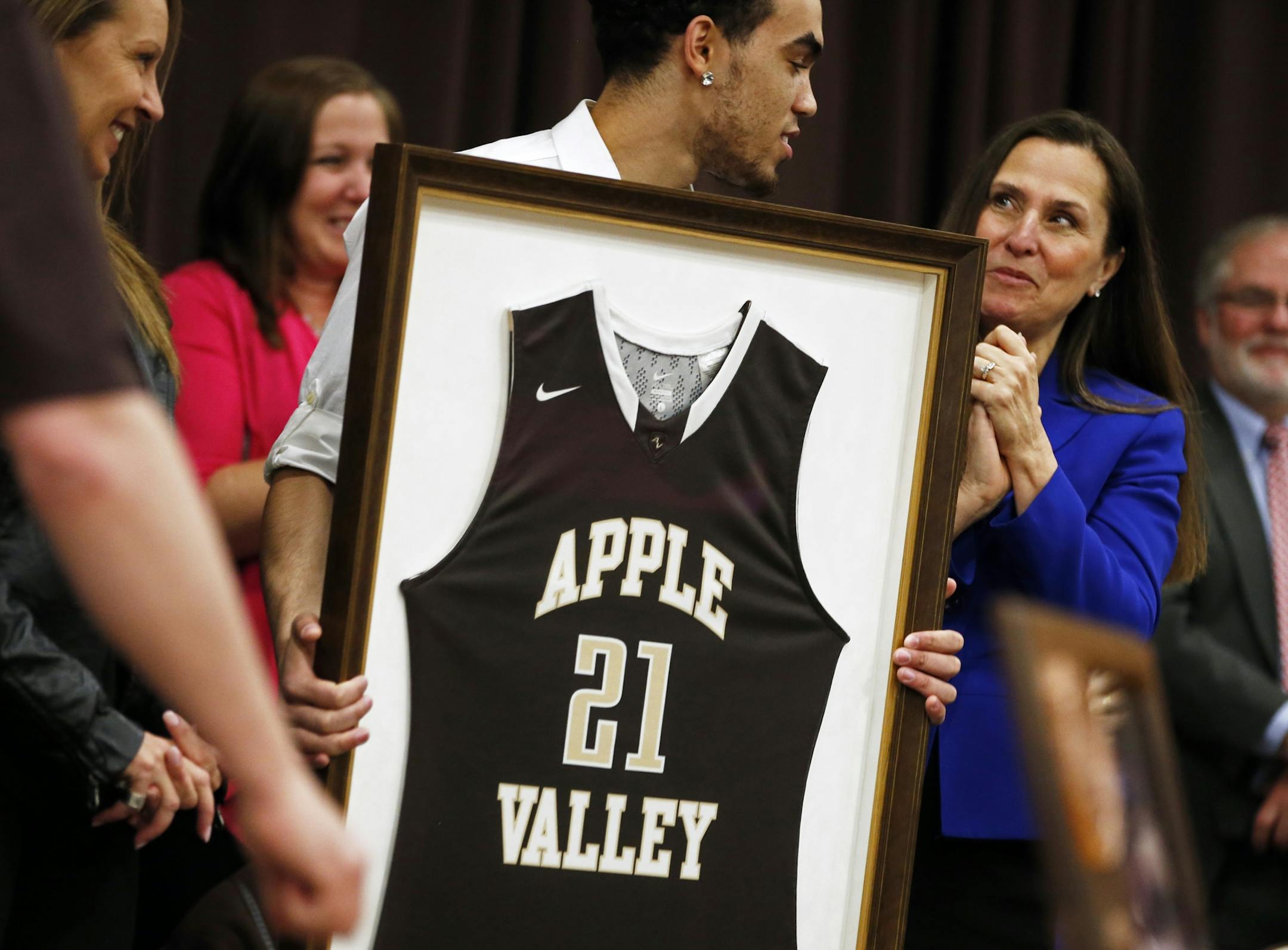 In Apple Valley, Tyus Jones got his number retired at an awards assembly at Apple Valley H.S. To the right is mayor Mary Hamann-Roland .
