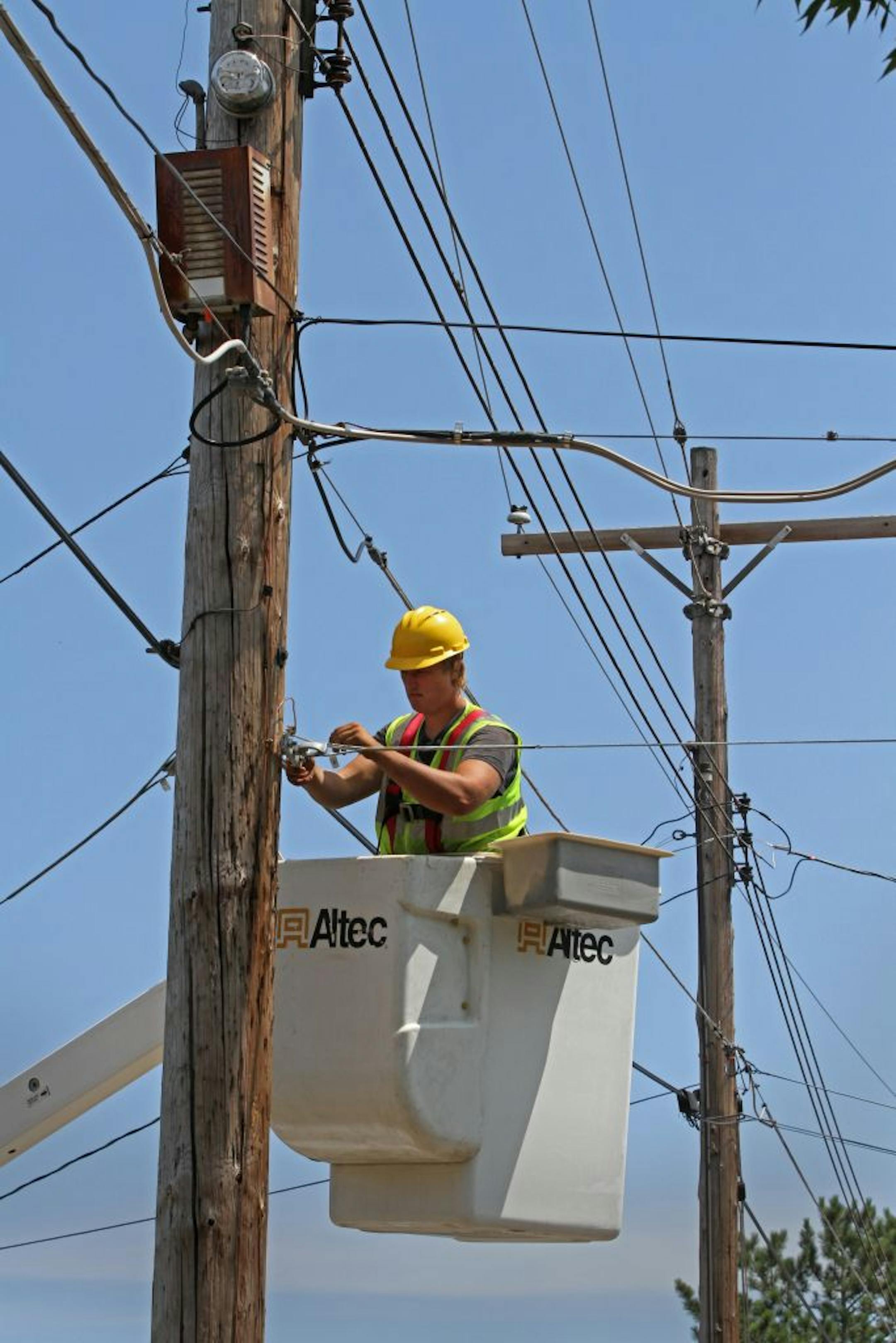 Seth Kern, with Lake States Construction, readied telephone poles in Two Harbors for installation of fiber-optic cable. The battle over rural broadband in northern Minnesota mimics a nationwide fight over the economics of providing service in rural areas.