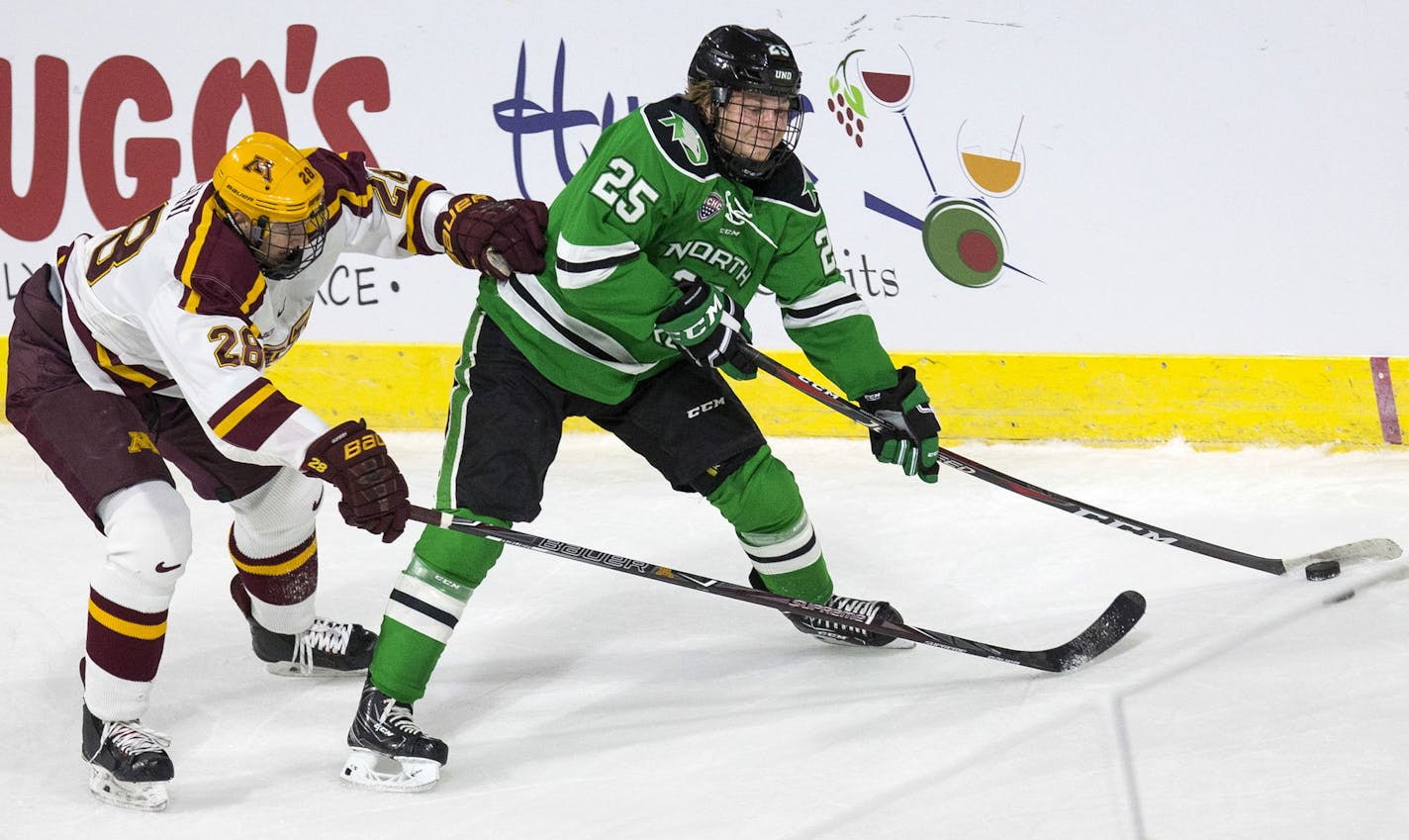 North Dakota Fighting Hawks forward Joel Janatuinen (25) passes the puck as Minnesota Golden Gophers defenseman Sam Rossini (28) defends during the first period of the U.S. Hockey Hall of Fame Game at the Orleans Arena in Las Vegas on Saturday, Oct. 27, 2018. Richard Brian Las Vegas Review-Journal @vegasphotograph