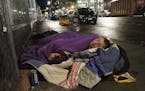 In this Sept. 18, 2017 photo, Taz Harrington, right, sleeps with his girlfriend, Melissa Ann Whitehead, on a street in downtown Portland, Ore. Harring