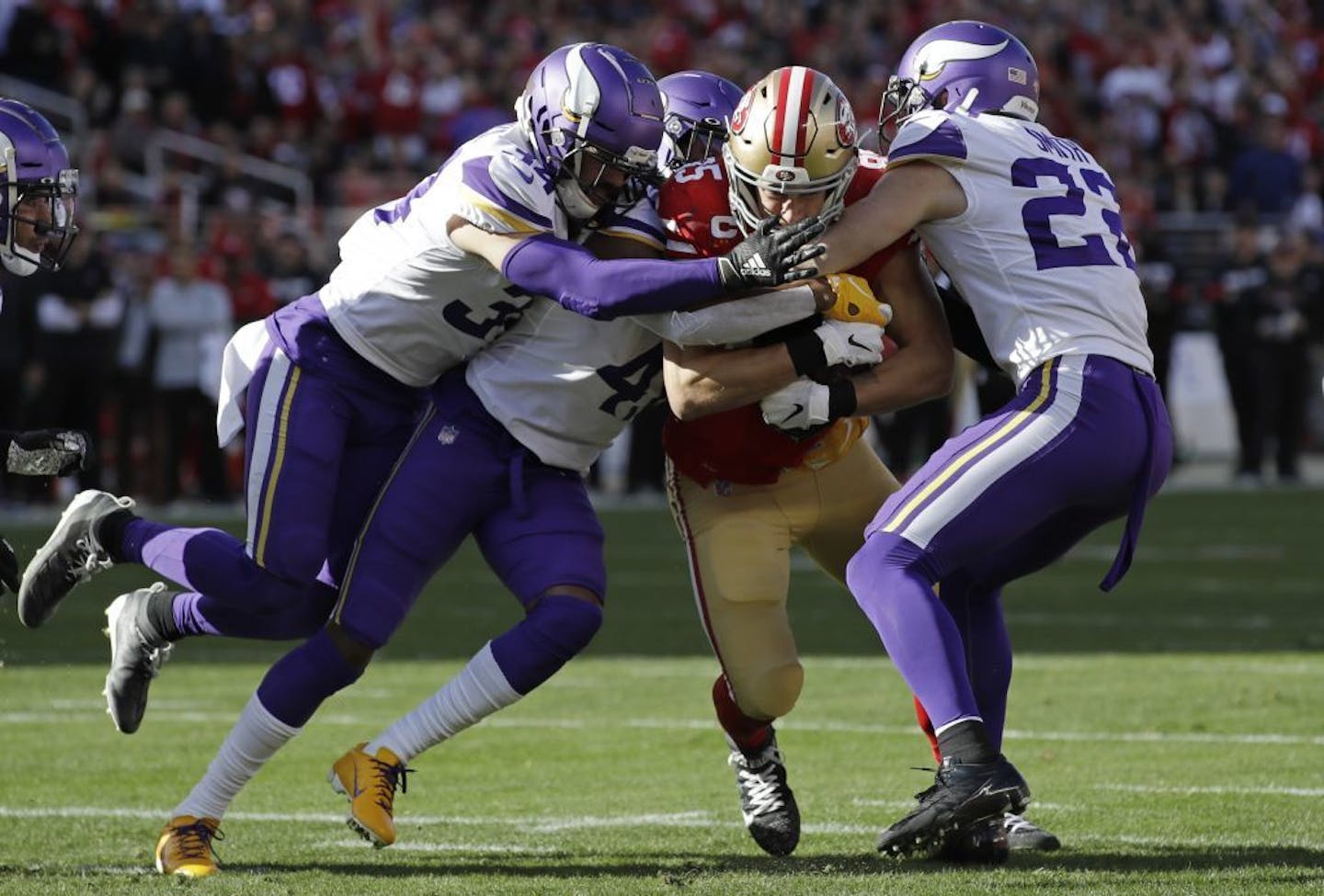 San Francisco 49ers tight end George Kittle, center, is tackled by Minnesota Vikings Minnesota Vikings free safety Harrison Smith, right, and other defenders during the first half of an NFL divisional playoff football game, Saturday, Jan. 11, 2020, in Santa Clara, Calif.