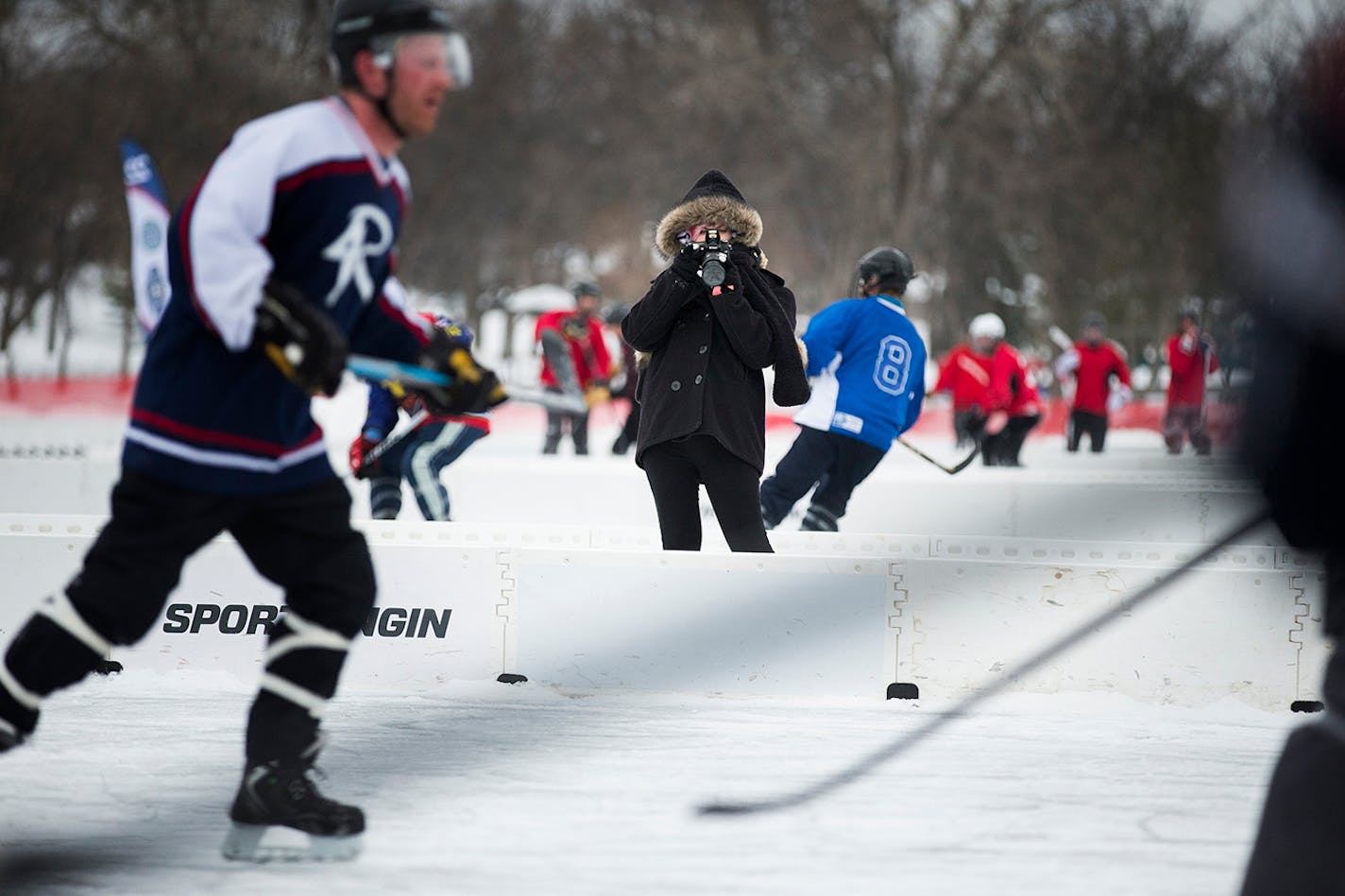 Abra Britnell of Orlando, Fla. takes photos of the 4Rivers Smokehouse team during the U.S. Pond Hockey Championships at Lake Nokomis in Minneapolis on Friday, January 16, 2015. ] LEILA NAVIDI leila.navidi@startribune.com /