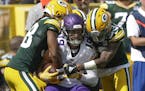 Minnesota Vikings' Adam Thielen catches a pass between Green Bay Packers' Tramon Williams and Jaire Alexander during the first half of an NFL football