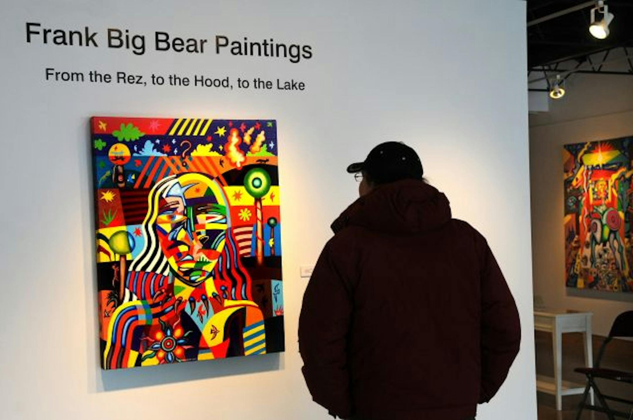Colorful mosaic-style paintings by Minnesota artist Frank Big Bear are focus of first show at All My Relations Gallery. Joseph Flores of Minneapolis looks over the show's signature painting, "Autumn's Wind."