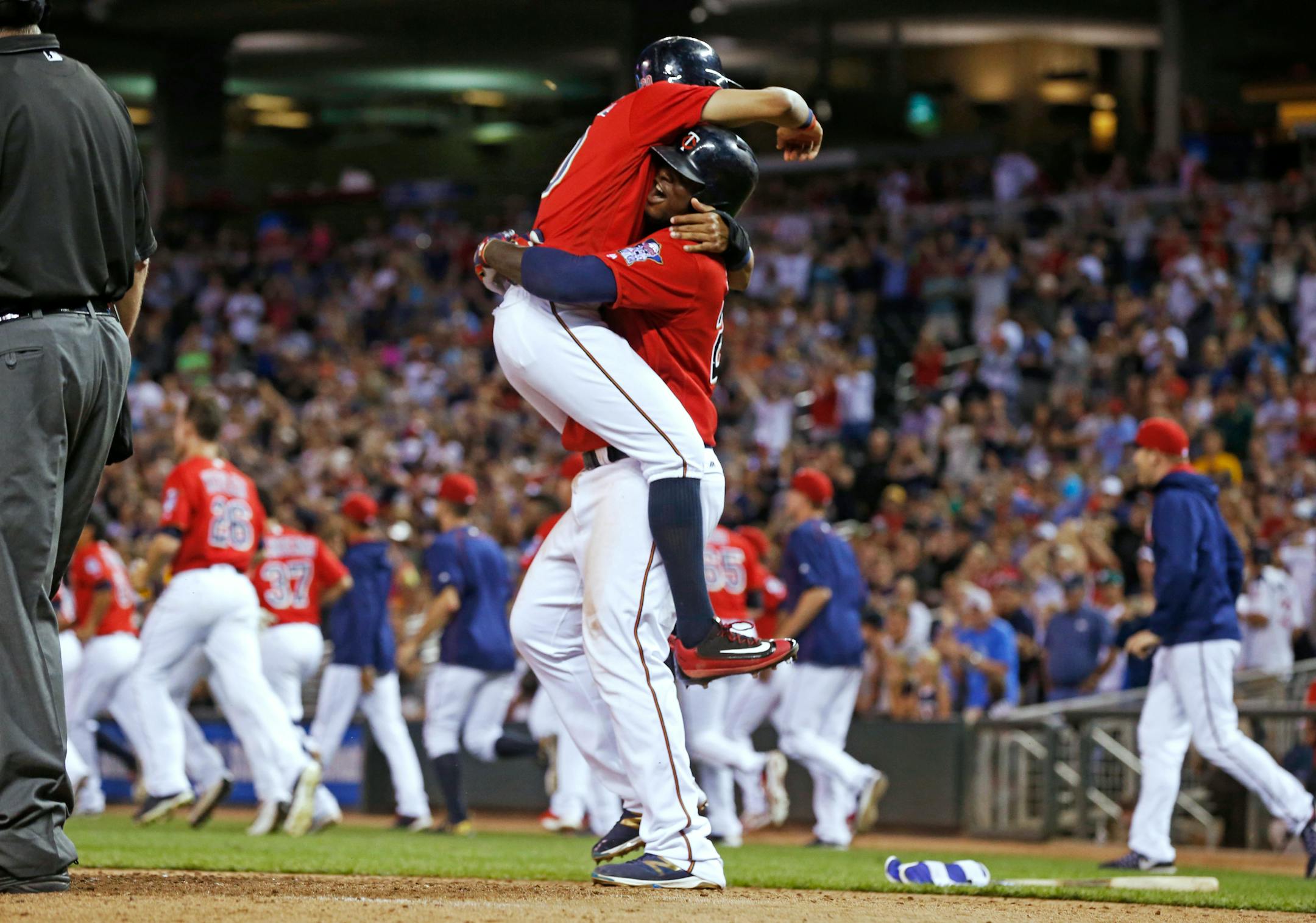 Minnesota Twins' Eddie Rosario is hoisted by Miguel Sano after he scored the winning run on a bases-loaded walk by Chicago White Sox pitcher Tommy Kahnle during the 12th inning of a baseball game Friday, July 29, 2016, in Minneapolis. The Twins won 2-1. (AP Photo/Jim Mone)