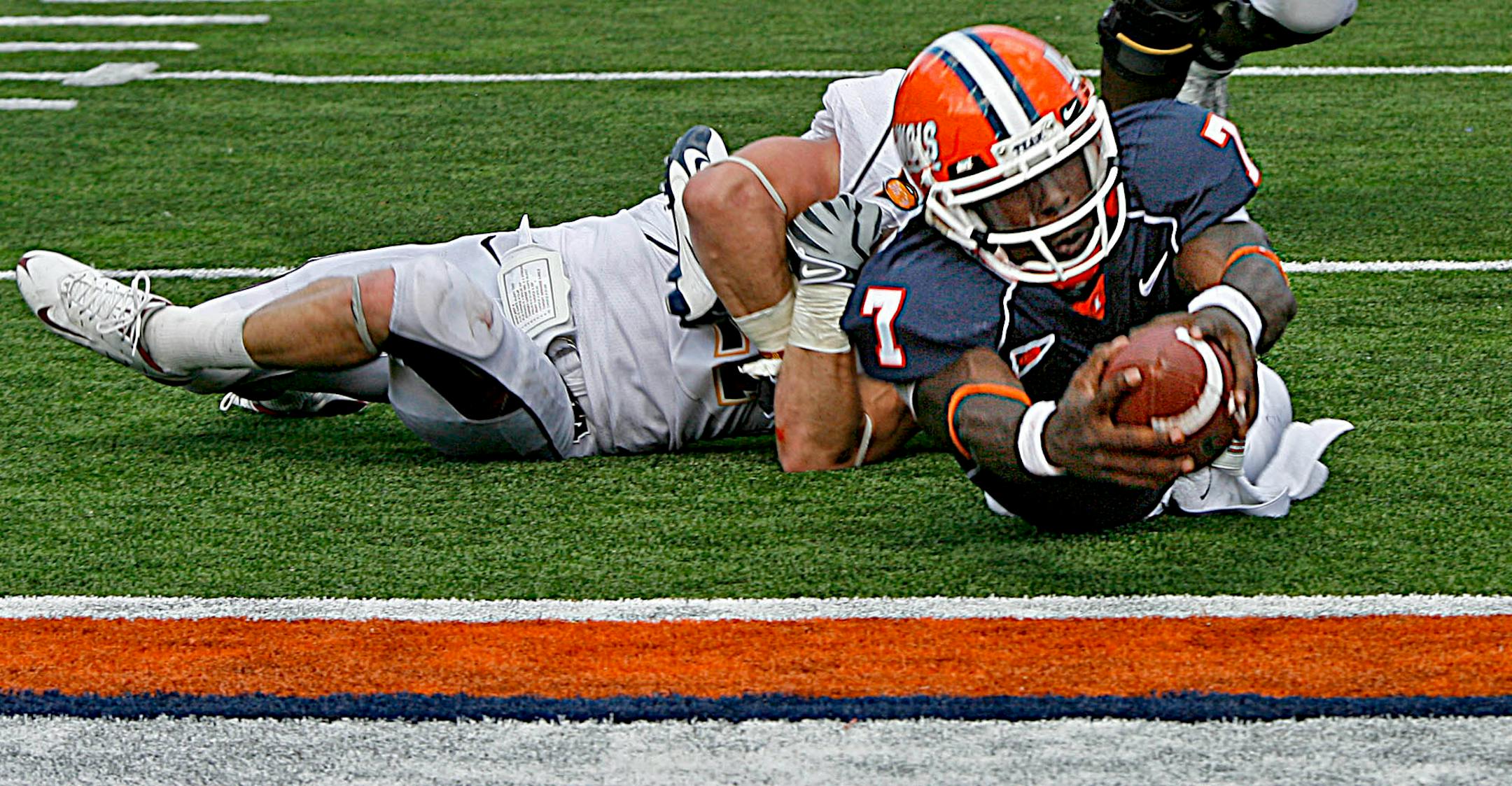 Gophers Kyle Theret held on to Ilinois quarterback Juice Williams to stop him from diving into the end zone in 3rd quarter action. The ball was marked at the half yard line and Illinois failed to score on the drive.