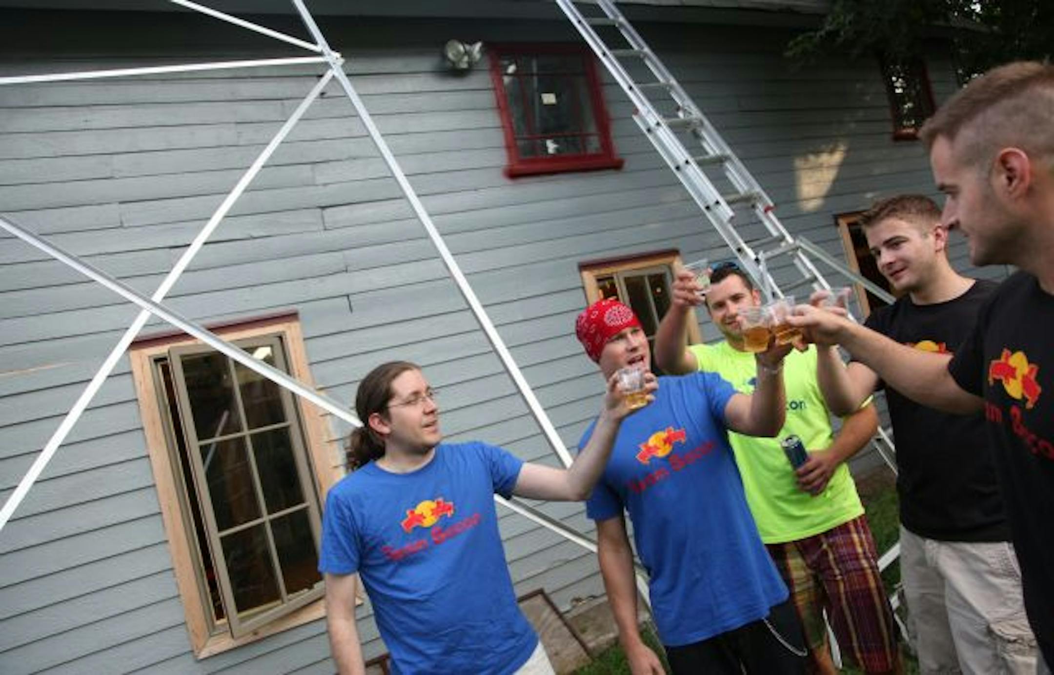 Team Bacon's craft has an 18-foot tower to give it extra room to fly. The team hopes to break flugtag's international distance record of 195 feet. From left, Matt dePratter, Chris Sunde, Brit Skolness, Josh Ridler and Joe Ridler paused to celebrate their design.