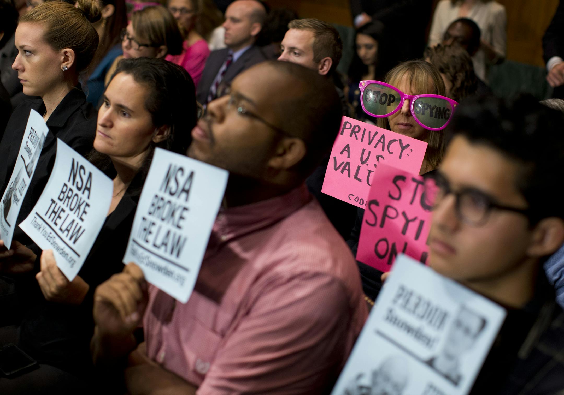 Protestors hold signs during an Oct. 2, 2013 Senate Judiciary Committee oversight hearing on the Foreign Intelligence Surveillance Act with National Security Agency leaders.