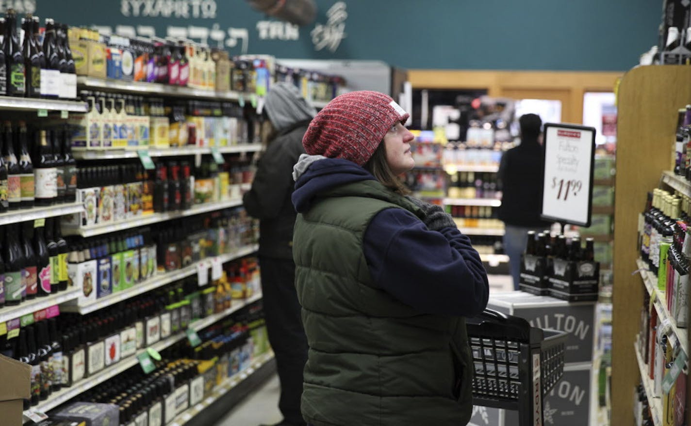 Susie Gindorff, 33, comes to shop in the Surdyk's liquor store in Minneapolis on Sunday, March 12, 2017. She said she heard about the sales from a Facebook post. The liquor store has gotten a head start on opening for business on Sundays. Surdyk's, a longtime liquor and cheese store in northeast Minneapolis, opened for business Sunday, despite Minnesota's new Sunday liquor sales law not taking effect until July. (Xavier Wang/Star Tribune via AP)