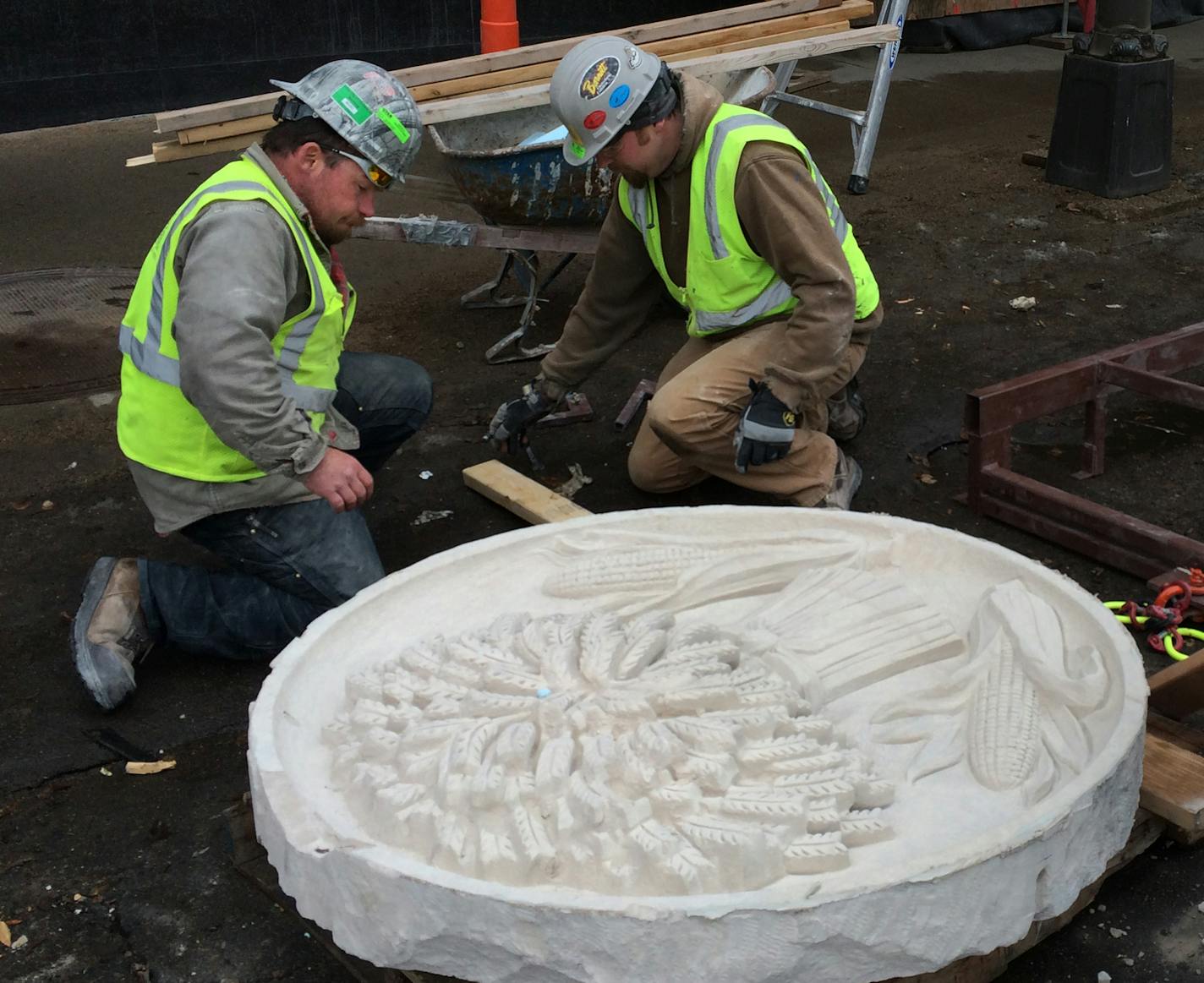 Bobby Tufts (left) and Travis Hudlow of Ryan Companies inspected the second of six historic medallions from the Star Tribune. ] MCKENNA EWEN mckenna.ewen@startribune.com - April 1, 2014, Minneapolis Star Tribune