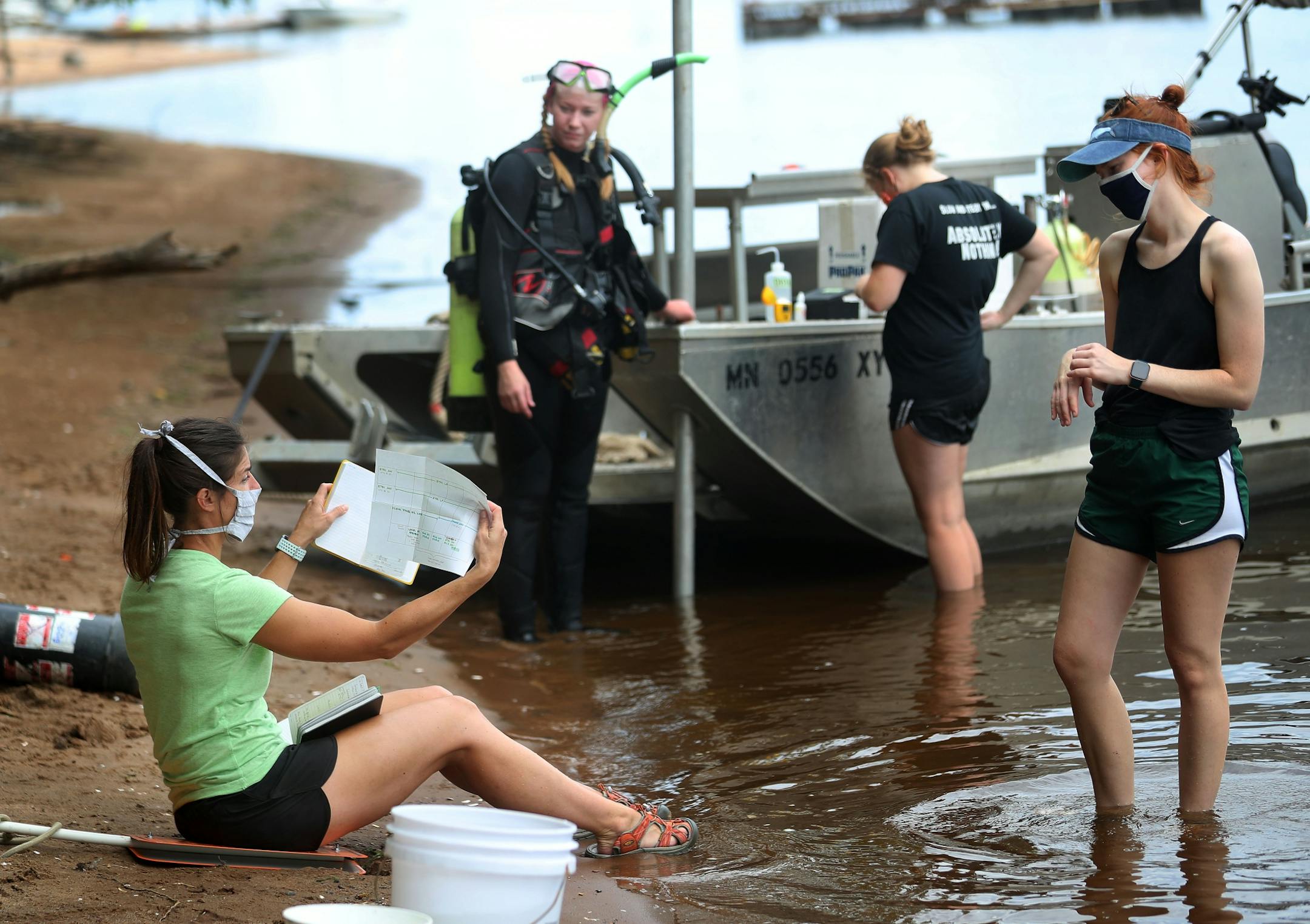 A Minnesota DNR crew transplanted 3,506 mussels native to Minnesota -- including Higgins' eye, bucket and snuffbox-- to grow in the waters of the St. Croix River, across from Hudson, WI, Tuesday in Lakeland, MN. Here, Madeline Pletta, seated, a mussel propagation biologist with the Minnesota Department of Natural Resources, holds notes about mussels transplanted in the St. Croix last year as fellow Minnesota DNR crew members Olivia Poleman, right to left, Anna Scheunemann and Lindsay Ohlman look
