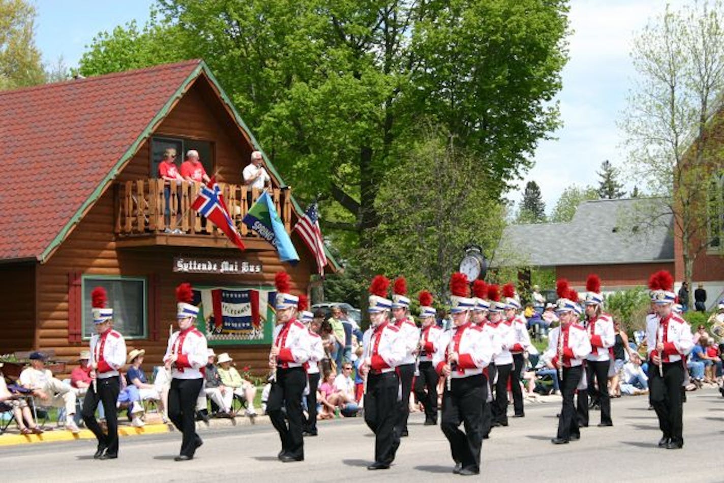 A band marches past the Syttende Mai Hus, flying the Norwegian and American flags, during the Syttende Mai parade in Spring Grove, Minn.