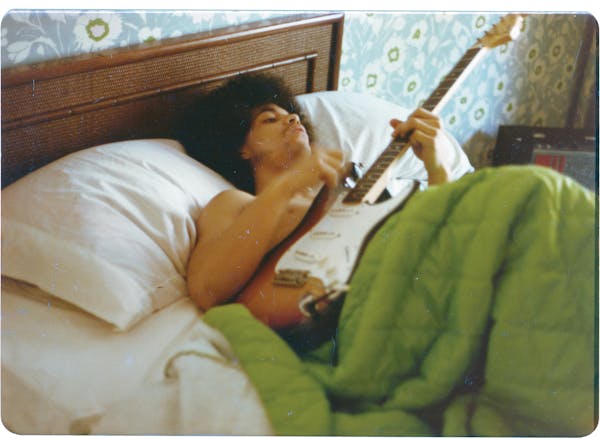 Prince lying in bed with guitar (&#xa9; 1986 Joseph Giannetti) CAPTION: Prince plays a guitar in bed at his new home on France Avenue, April 1978.