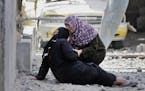 Palestinian Manal Keferna, 30, right, cries with her sister-in-law Najwa Keferna upon their return to the family house destroyed by Israeli strikes in
