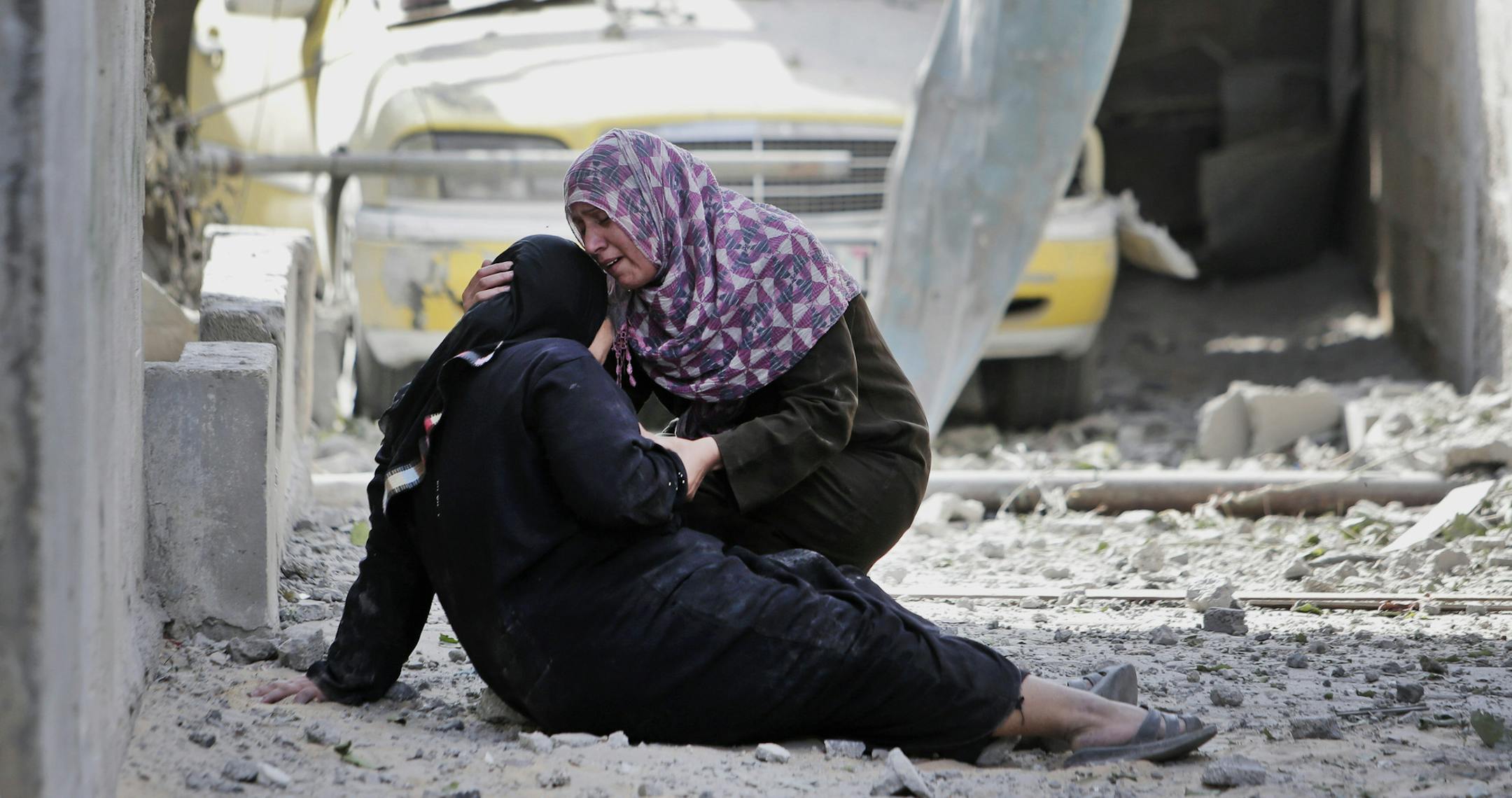 Palestinian Manal Keferna, 30, right, cries with her sister-in-law Najwa Keferna upon their return to the family house destroyed by Israeli strikes in Beit Hanoun, northern Gaza Strip, Saturday, July 26, 2014. Thousands of Gaza residents who had fled Israel-Hamas fighting streamed back to devastated border areas during a lull Saturday to find large-scale destruction: scores of homes were pulverized, wreckage blocked roads and power cables dangled in the streets. (AP Photo/Lefteris Pitarakis) ORG