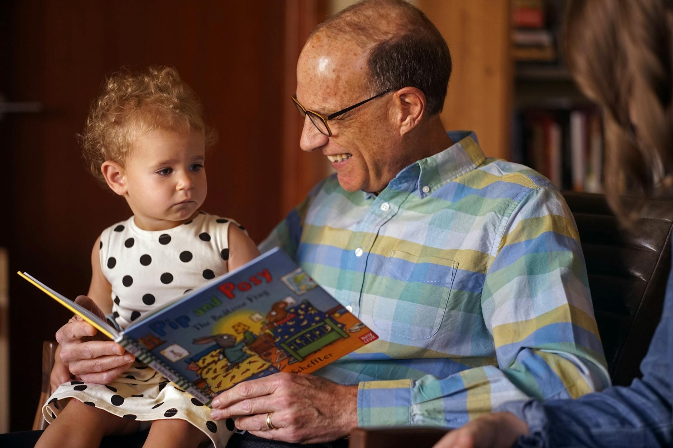 Hart Kuller reads to his granddaughter Rozlyn.