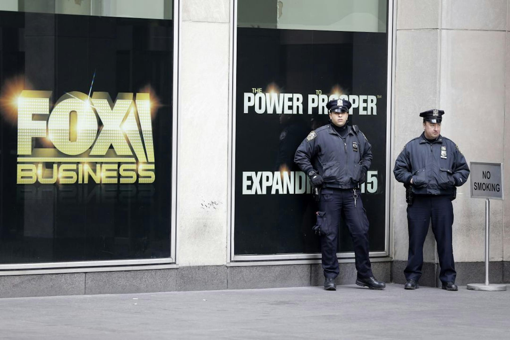 New York City police officers stand guard outside the building that houses Rupert Murdoch's News Corp headquarters in Midtown Manhattan on Friday, Jan. 16, 2015. In the wake of the Paris terror attacks in early January, New York's Police Department is quietly expanding training for what it sees as the latest terror threat � teams of "active shooters" who arm themselves with high-powered rifles and open fire.