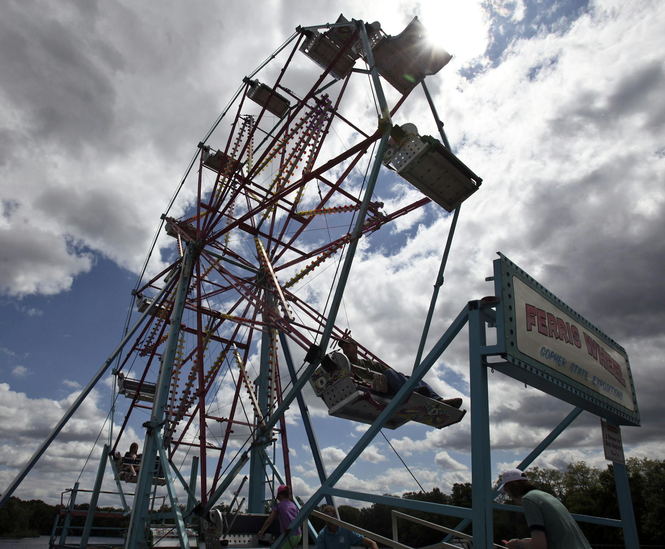 KYNDELL HARKNESS ‚Ä¢ kyndell.harkness@startribune.com CHAMPLIN 06/10/11 Father Hennepin Festival event -- Carnival, petting zoo, contests, bicycle stunt show, live entertainment and parade. IN THIS PHOTO ] Festival goers made their way onto the ferris wheel during the second day of the Father Hennepin Festival in Champlin.