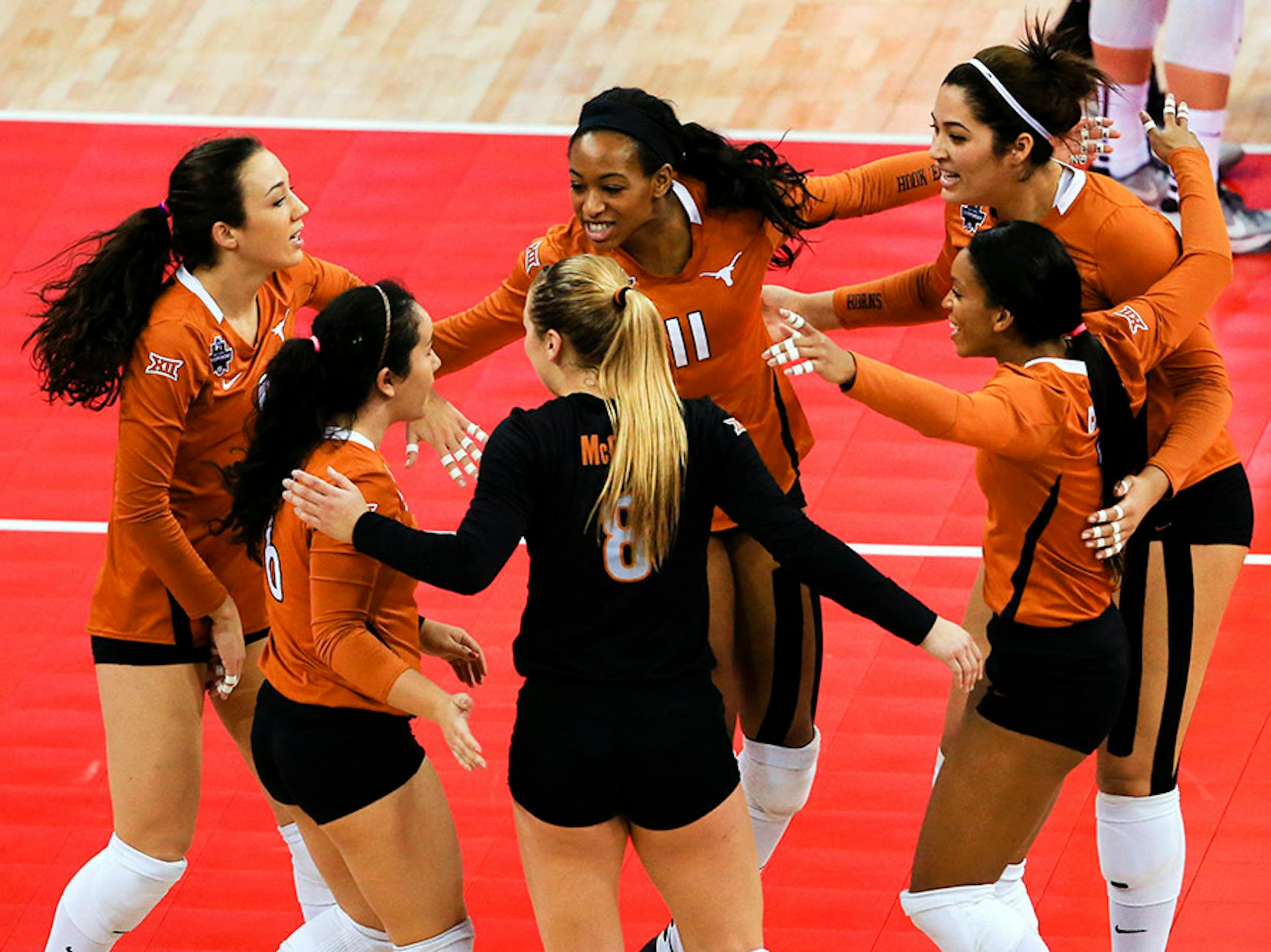Texas players, including Chiaka Ogbogu (11), celebrate a point against Minnesota during an NCAA women's volleyball tournament semifinal in Omaha, Neb., Thursday, Dec. 17, 2015.