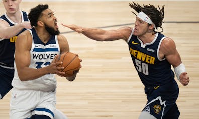 Denver Nuggets forward Aaron Gordon, right, applies to pressure to Minnesota Timberwolves center Karl-Anthony Towns during the first quarter of Game 4