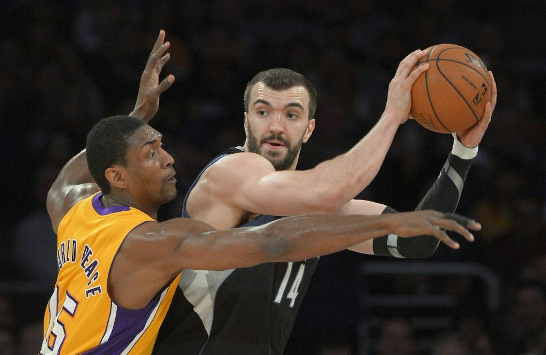 Lakers forward Metta World Peace reaches for the ball held by Timberwolves center Nikola Pekovic.