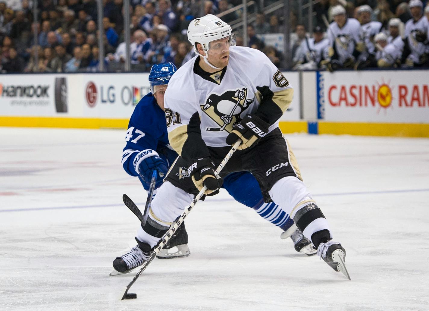 Pittsburgh Penguins' Phil Kessel breaks into the offensive zone against the Toronto Maple Leafs' Leo Komarov during second period NHL action, in Toronto, on Saturday, Oct. 31, 2015. (Kevin Van Paassen/The Canadian Press via AP)