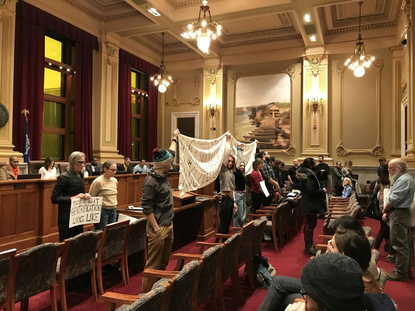 Opponents of the Upper Harbor Terminal redevelopment stood with their backs to the Minneapolis City Council following the unanimous approval of the project's concept plan Friday, March 1, 2019.