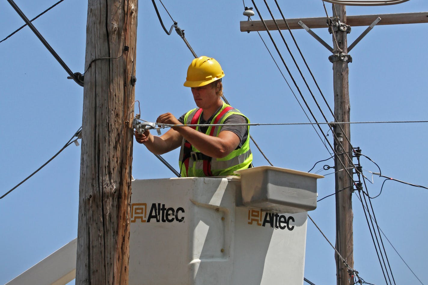 Seth Kern, with Lake States Construction, a sub-contractor of Lake Connections, readied telephone poles in Two Harbors to string stainless steel strand cables from which fiber optic cable will be lashed to on 7/31/12. By the time the communications project is done in 2014 around 2000 miles of fiber optic cable will be strung, connecting customers with broadband internet, video and telephone service. ] Bruce Bisping/Star Tribune bbisping@startribune.com ORG XMIT: MIN2015041415464351