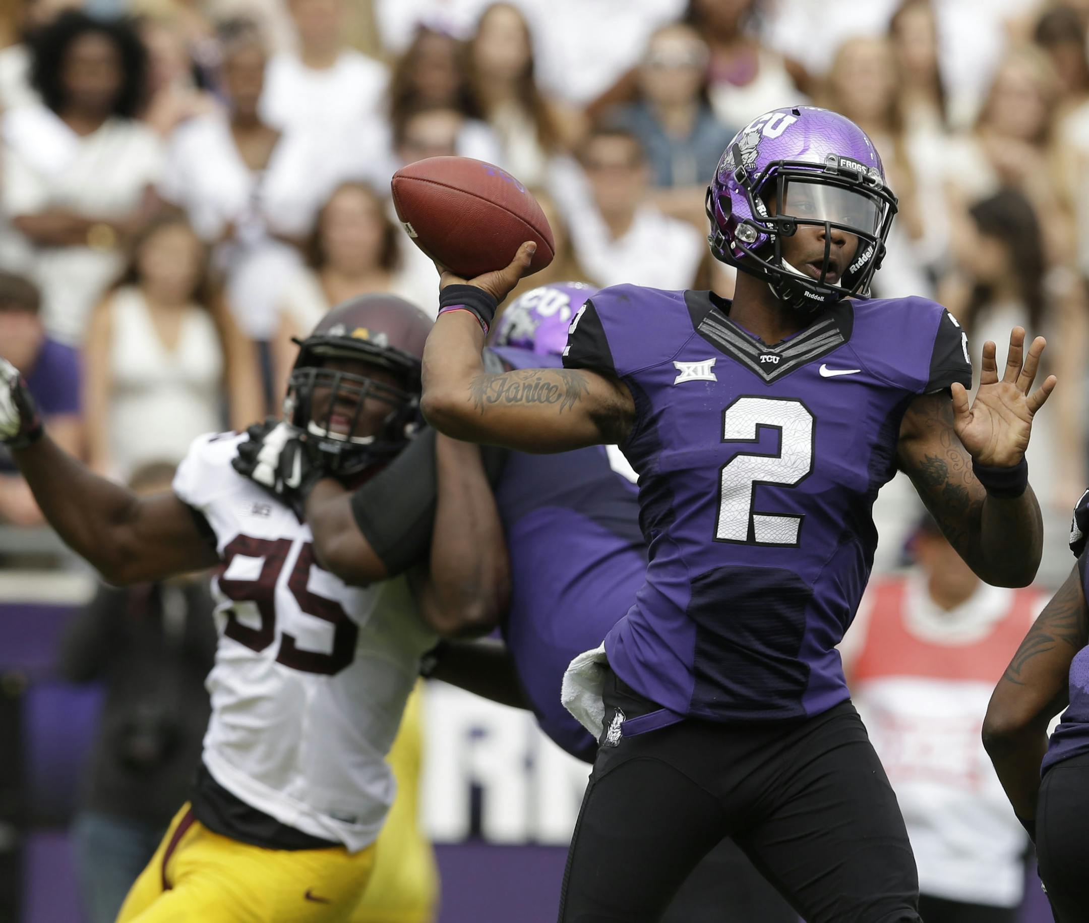 TCU quarterback Trevone Boykin (2) passes the ball as Minnesota defensive lineman Hendrick Ekpe (95) is blocked during the first half of an NCAA college football game, Saturday, Sept. 13, 2014, in Fort Worth, Texas. (AP Photo/LM Otero) ORG XMIT: TXMO102