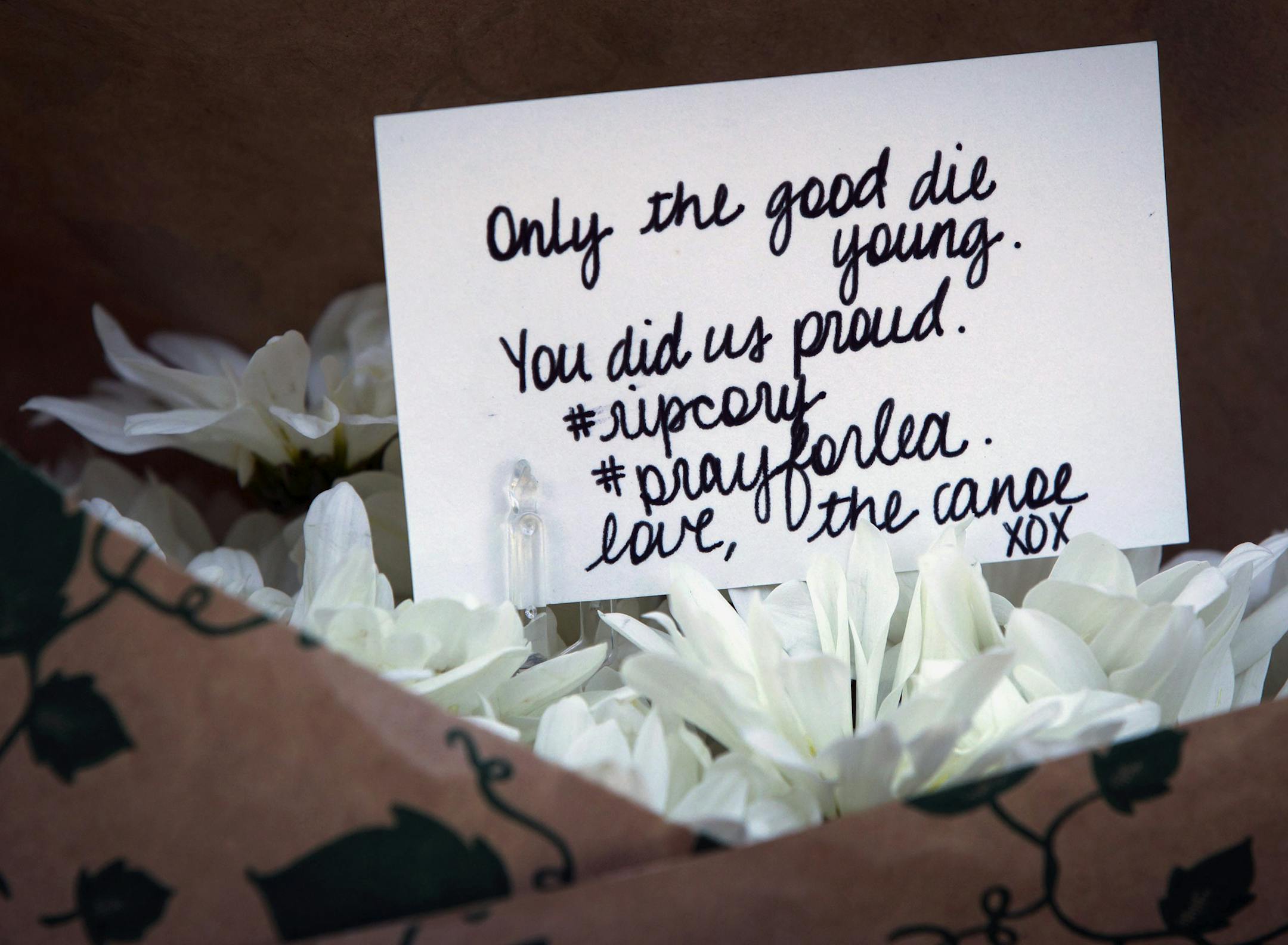 A handwritten card is placed among flowers at a small memorial to Canadian actor Cory Monteith outside the Fairmont Pacific Rim Hotel in Vancouver, British Columbia, on Sunday July 14, 2013. Monteith's body was found in a room at the hotel Saturday. (AP Photo/The Canadian Press, Darryl Dyck)