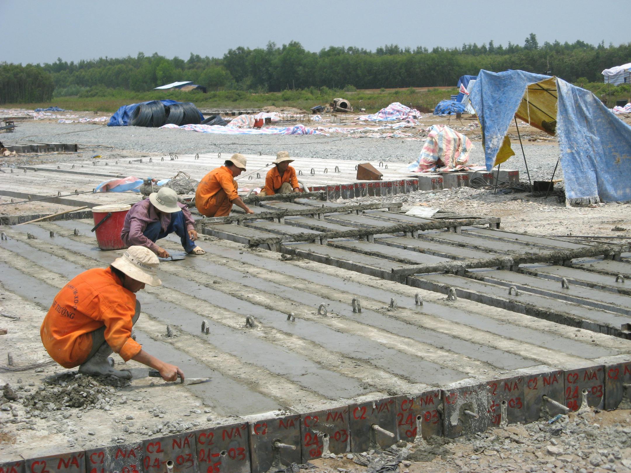 NEAL ST. ANTHONY � nstanthony@startribune.com -- Vietnamese laborers build the yards-long pilings that seat the plant on ground in Cu Chi District where thousands of U.S. troops and Vietnamese troops fought in the late 1960s.