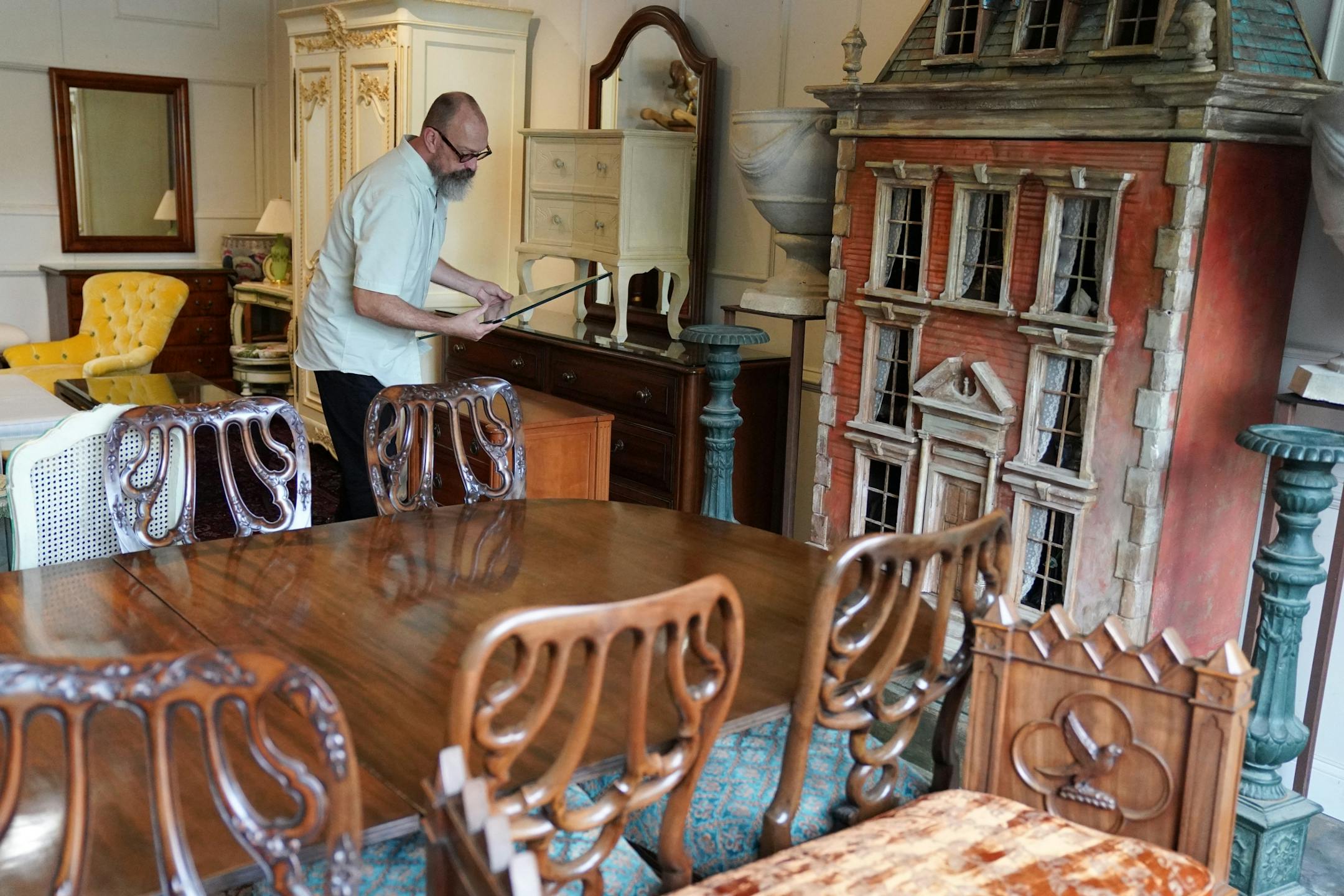 Jonathan Campbell arranged contents of Pillsbury mansion, recently demolished on Lake Minnetonka, that will go up for sale this weekend at H & B Gallery. The house on the right is an original prop from The Guthrie.