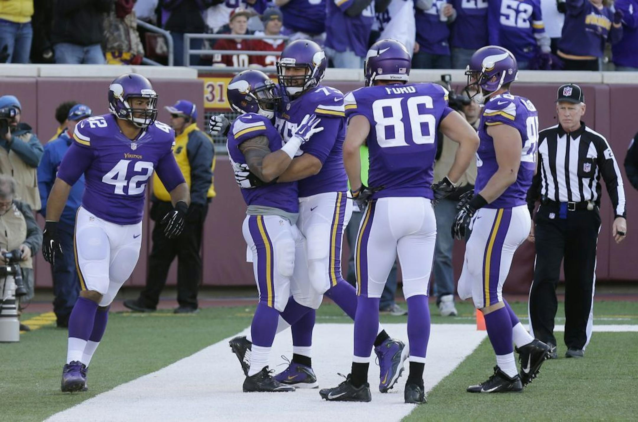 Minnesota Vikings running back Matt Asiata, second from left, celebrates with teammates after scoring on a 1-yard touchdown run in the second half of an NFL football game against the Washington Redskins, Sunday, Nov. 2, 2014, in Minneapolis.