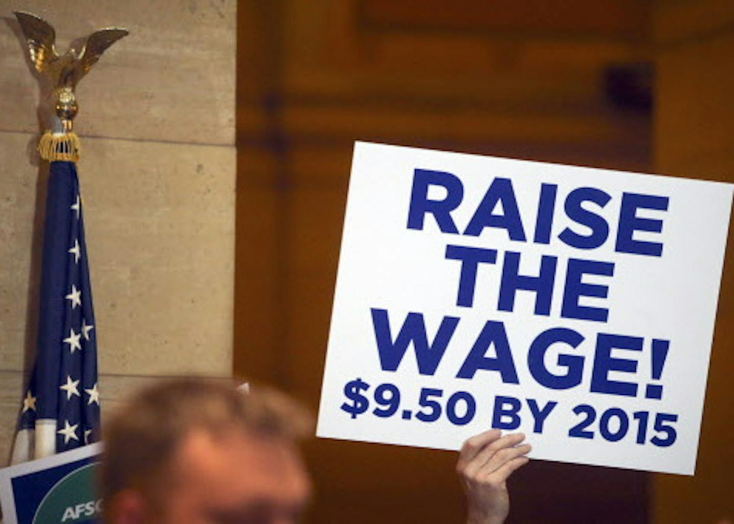 A man held up a sign as AFSCME council 5 members rallied to challenge the income and oppurtunity gaps that threaten communities and undermine shared prosperity Tuesday, March 25, 2014, at the State Capitol in St. Paul, MN.](DAVID JOLES/STARTRIBUNE) djoles@startribune.com A Rally by members of AFSCME council 5, with almost 1,000 members preregistered, to challenge income gaps and advocate for higher minimum wage. ORG XMIT: MIN1403251443200548