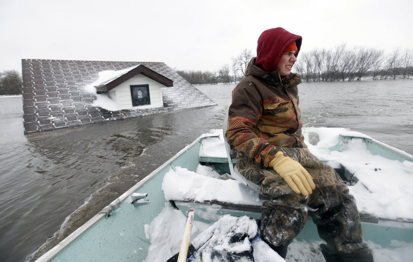 Richard Tsong-Taatarii/rtsong-taatarii@startribune.com Fargo, N.D.,3/25/09;left to right: Michael Stensgard uses one of his family's boat to get back to their home in a home yards from the Red River. The water is over 40 ft and has completely surrounded their home. ** MANDATORY CREDIT, ST. PAUL PIONEER PRESS OUT, MAGS OUT, TWIN CITIES TV OUT **