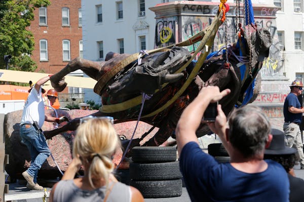 Crews in Richmond, Va., lowered a statue of Confederate Gen. J.E.B. Stuart in preparation for transport after removing it from its pedestal on Monumen