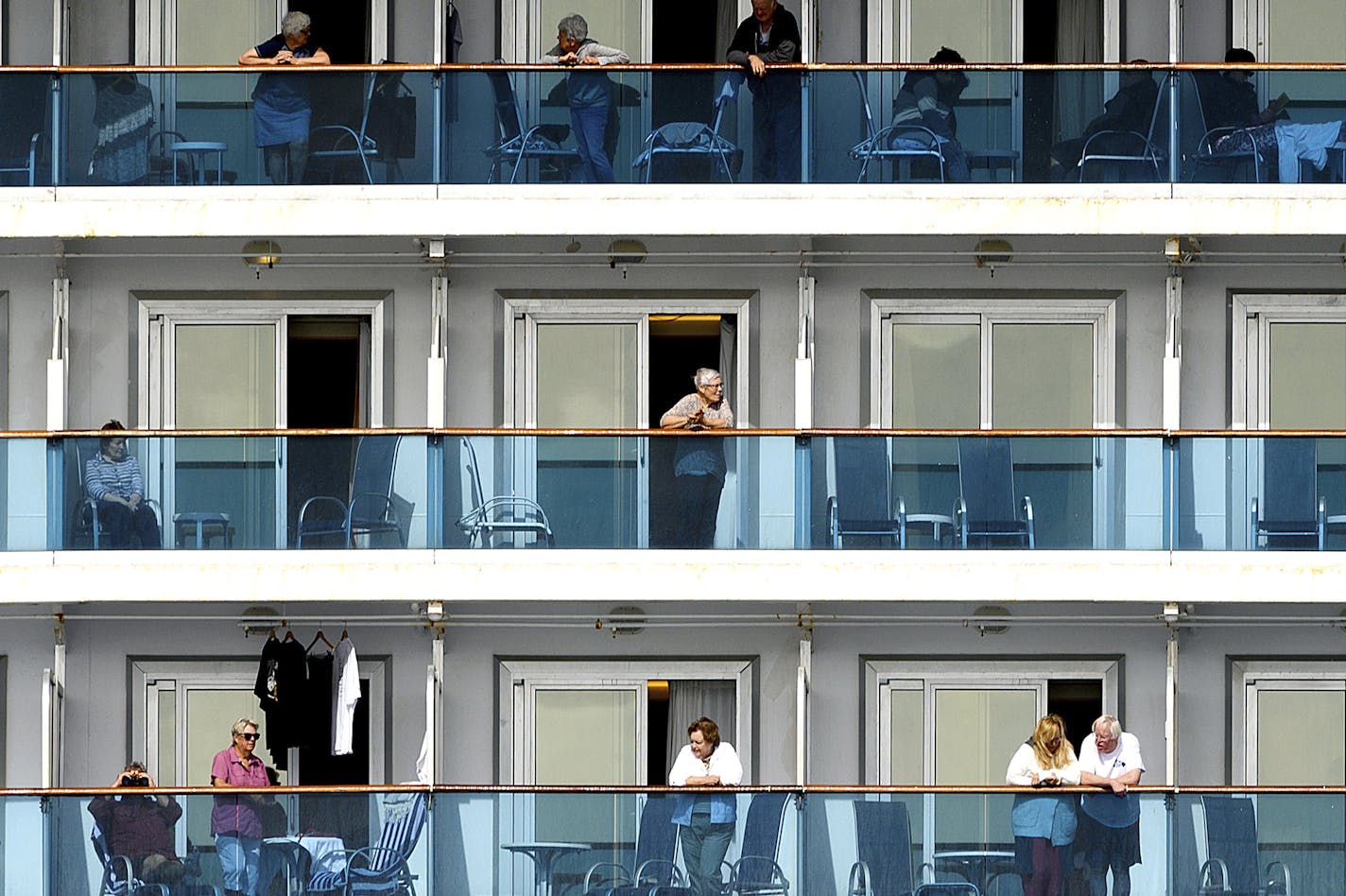 Passengers look out from balconies aboard the Grand Princess as it cruises a holding pattern about 25 miles off the coast of San Francisco on Sunday, March 8, 2020. The ship is expected to dock in Oakland in the east San Francisco Bay on Monday. California Gov. Gavin Newsom and the mayor of Oakland sought Sunday to reassure the public that none of the passengers from the ship with multiple cases of the new coronavirus will be released into the public before undergoing a 14-day quarantine. (AP Ph